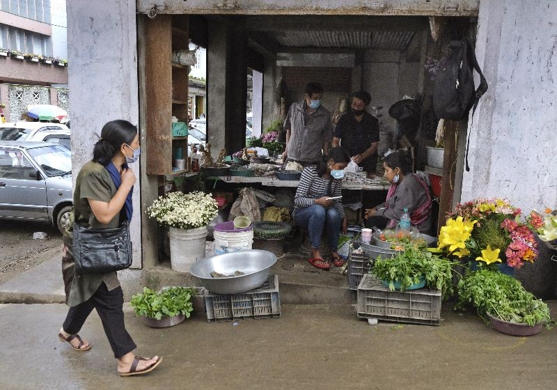 A Naga woman walks past shops in a market area in Kohima, capital of the northeastern Indian state of Nagaland, Wednesday, June 10, 2020. (Photo by Yirmiyan Arthur/AP Photo)